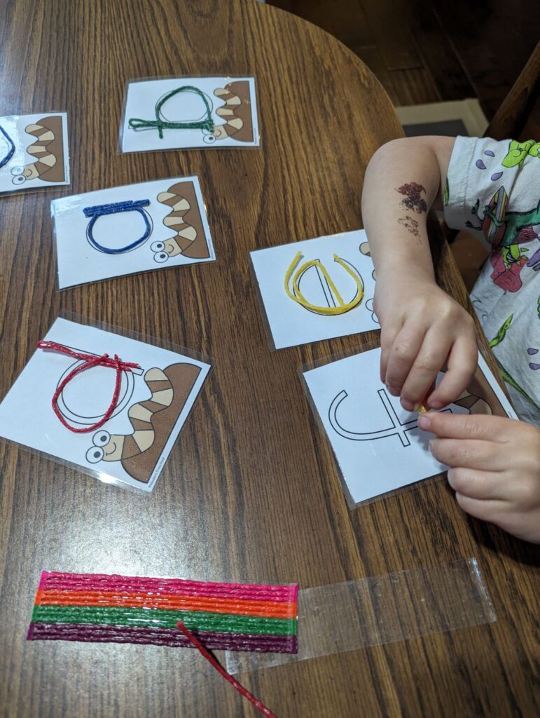 child using wax sticks to form alphabet letters